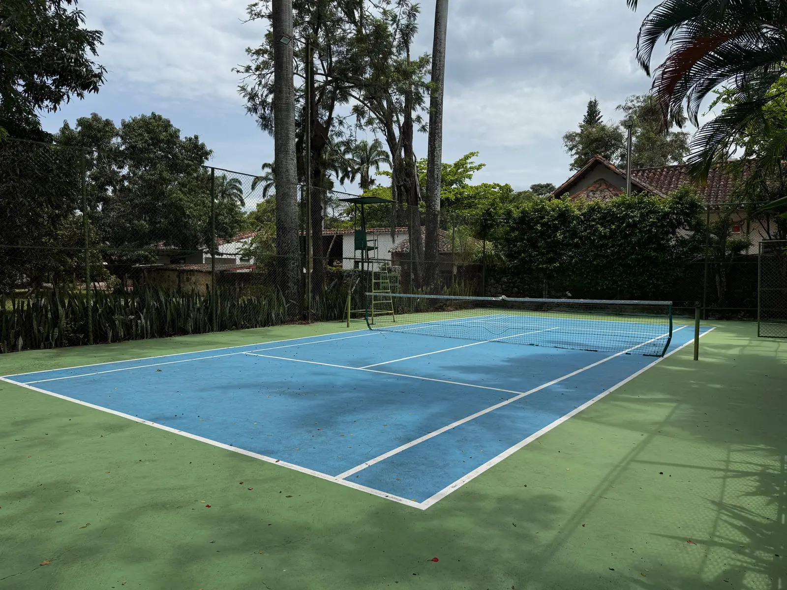 Cancha de tenis entre los jardines tropicales